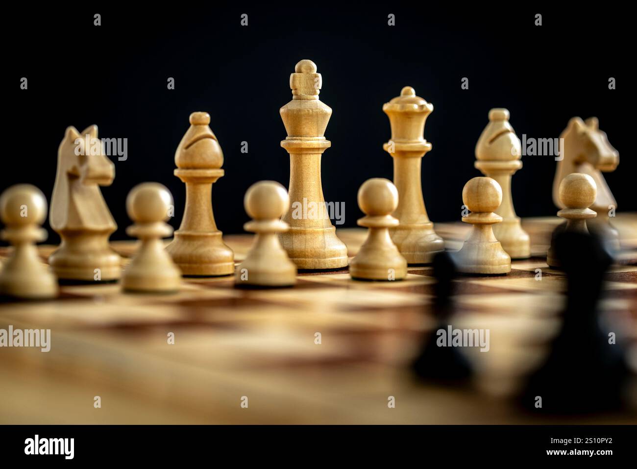 Weiße hölzerne Schachfiguren stehen auf einem Schachbretthintergrund Stockfoto
