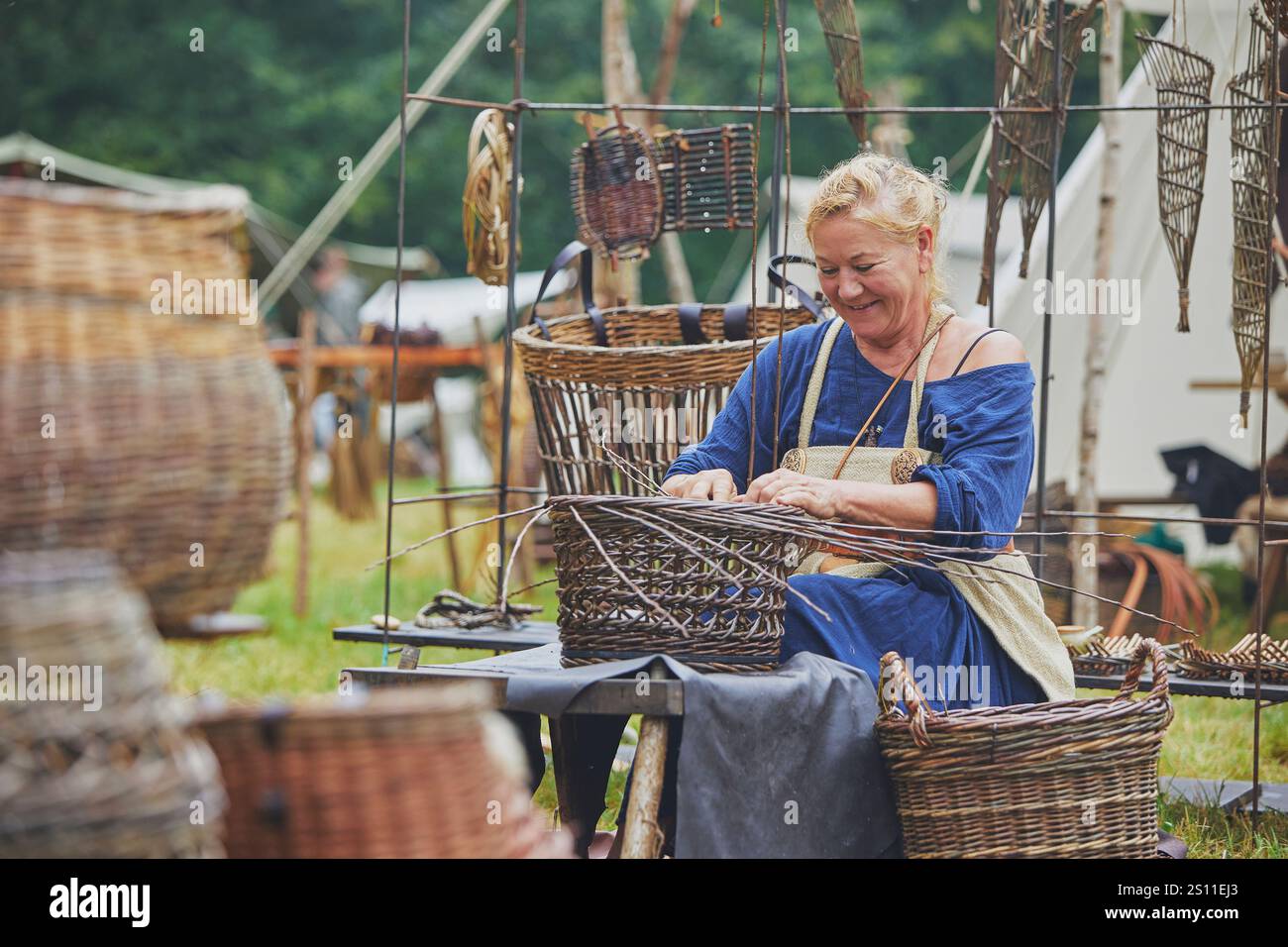 Hojbjerg, Dänemark, 27. Juli 2024: Weben einer Frau auf einem wikingerfest Stockfoto