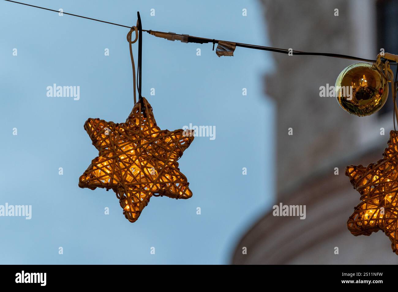 Hübsches leuchtendes Sternenschmuck, das an einer Lichterkette hängt, Weihnachtsschmuck Stockfoto