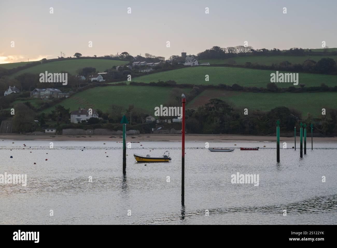Winterblick auf East Portlemouth, von Salcombe aus aufgenommen, kurz nach Sonnenaufgang mit dem Wasser leer von Booten, aber mit der Wasserruhe. Stockfoto