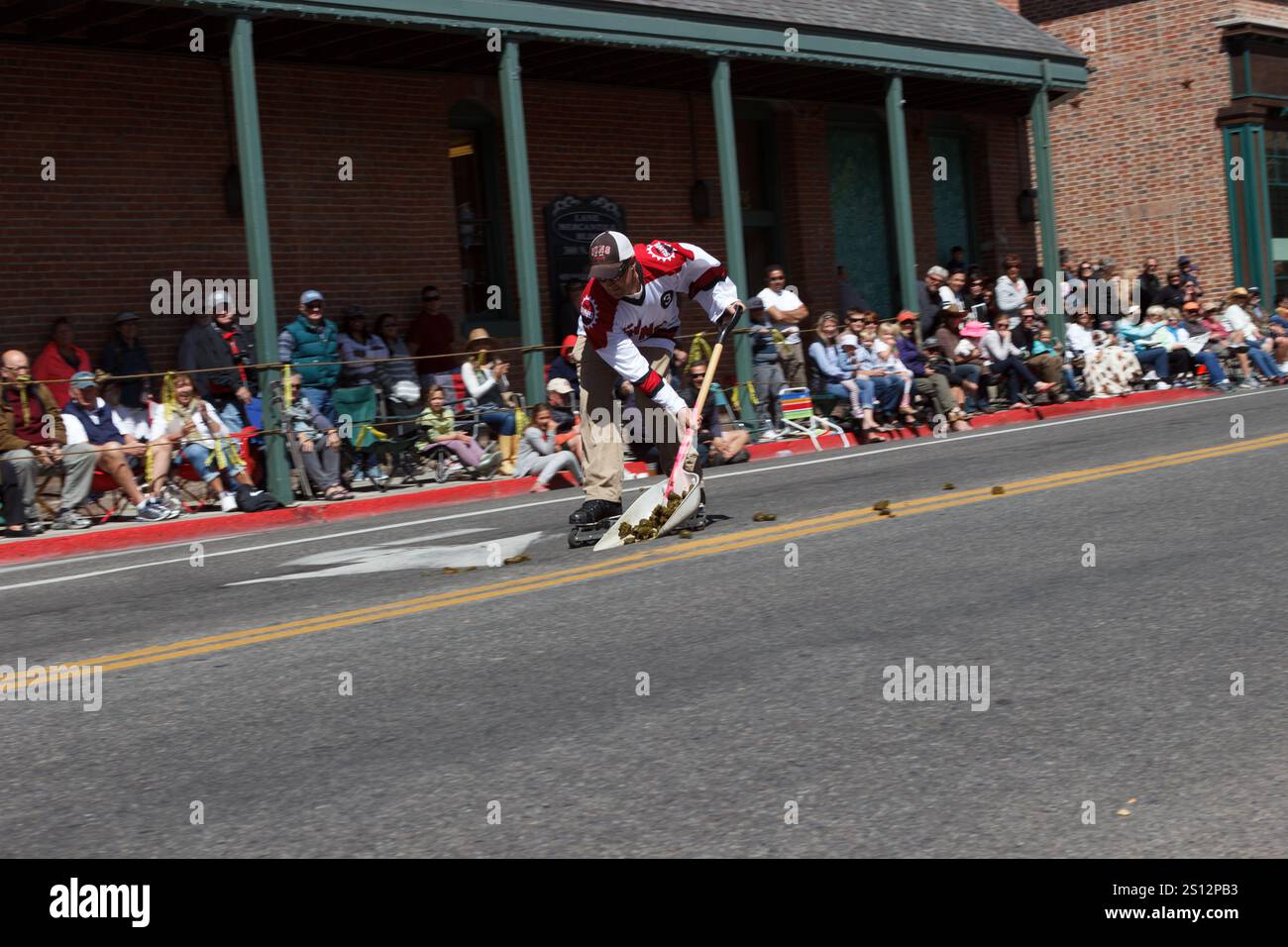 Mann in Hackey Jersey, der am Mist Pick Up Event bei Public Parade, Wagon Days, Sun Valley, Idaho teilnimmt Stockfoto