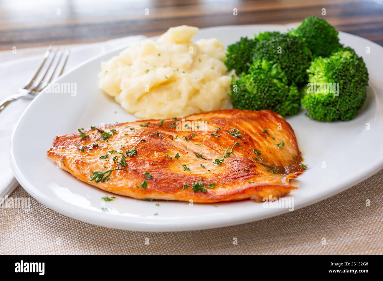 Blick auf einen Teller mit gegrilltem Lachs, gedämpftem Brokkoli und Kartoffelpüree. Stockfoto