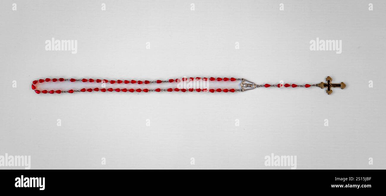 Kreatives Foto eines katholischen Rosenkranzes mit rotem Rubin ​​beads Stockfoto