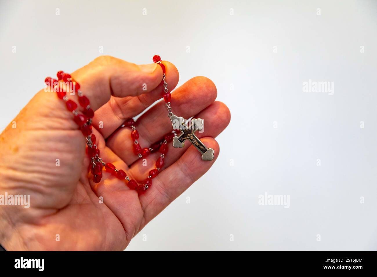 Kreatives Foto eines katholischen Rosenkranzes mit rotem Rubin ​​beads Stockfoto