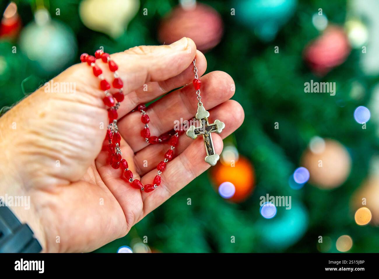 Kreatives Foto eines katholischen Rosenkranzes mit rotem Rubin ​​beads Stockfoto
