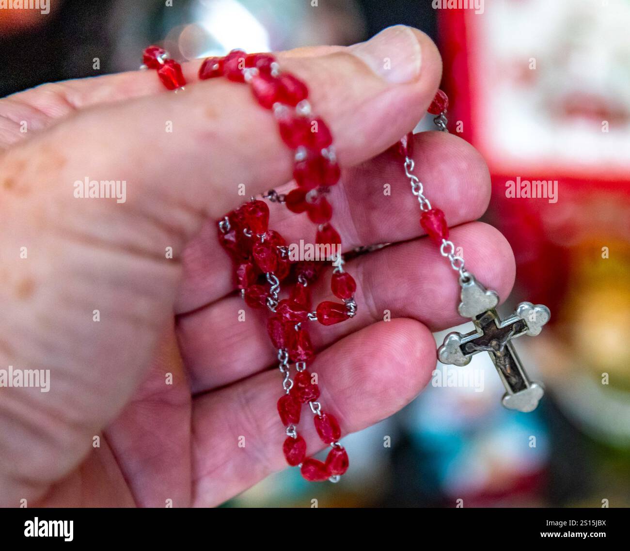 Kreatives Foto eines katholischen Rosenkranzes mit rotem Rubin ​​beads Stockfoto