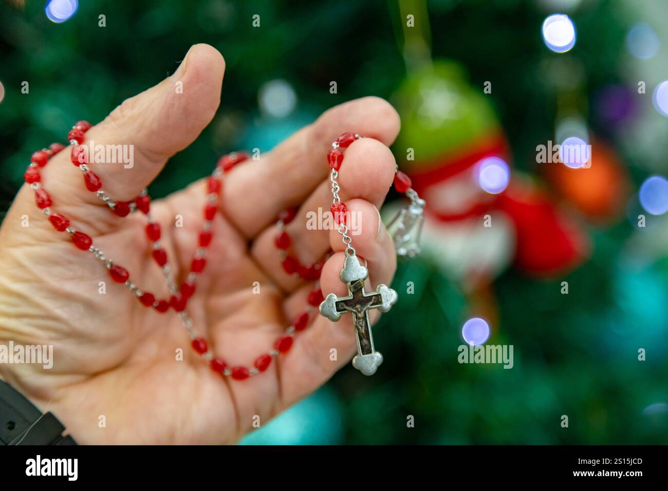 Kreatives Foto eines katholischen Rosenkranzes mit rotem Rubin ​​beads Stockfoto