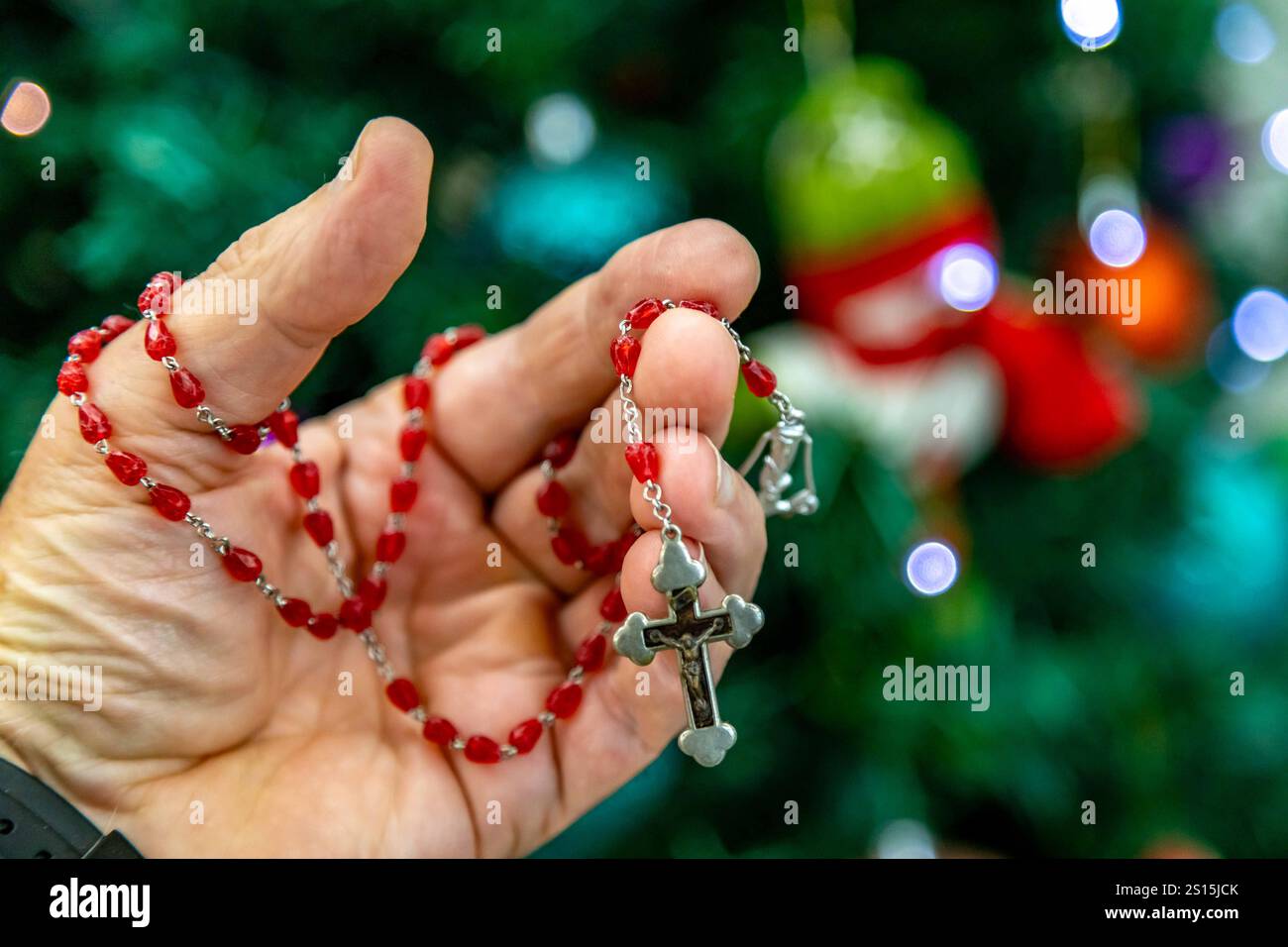 Kreatives Foto eines katholischen Rosenkranzes mit rotem Rubin ​​beads Stockfoto