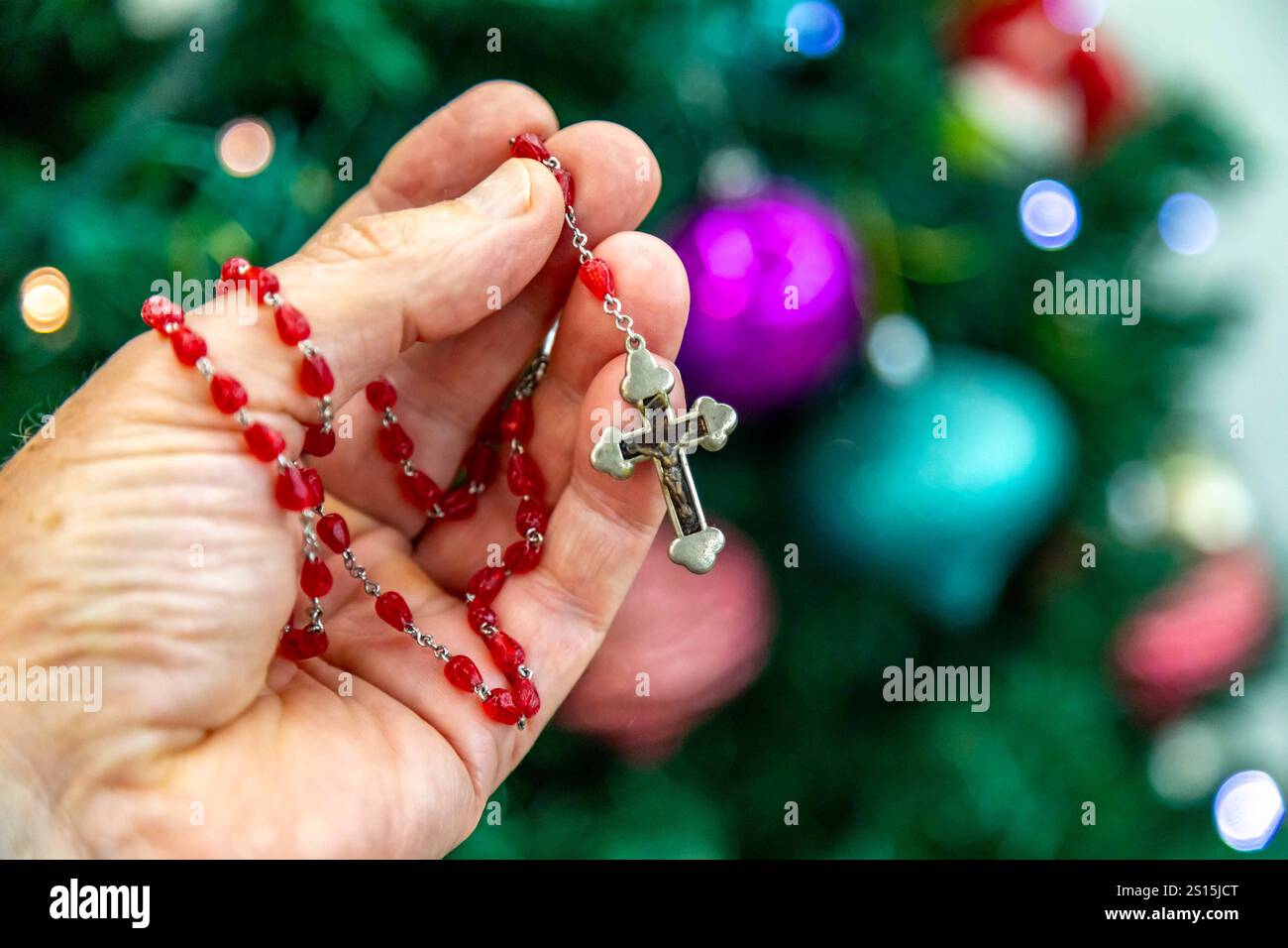 Kreatives Foto eines katholischen Rosenkranzes mit rotem Rubin ​​beads Stockfoto