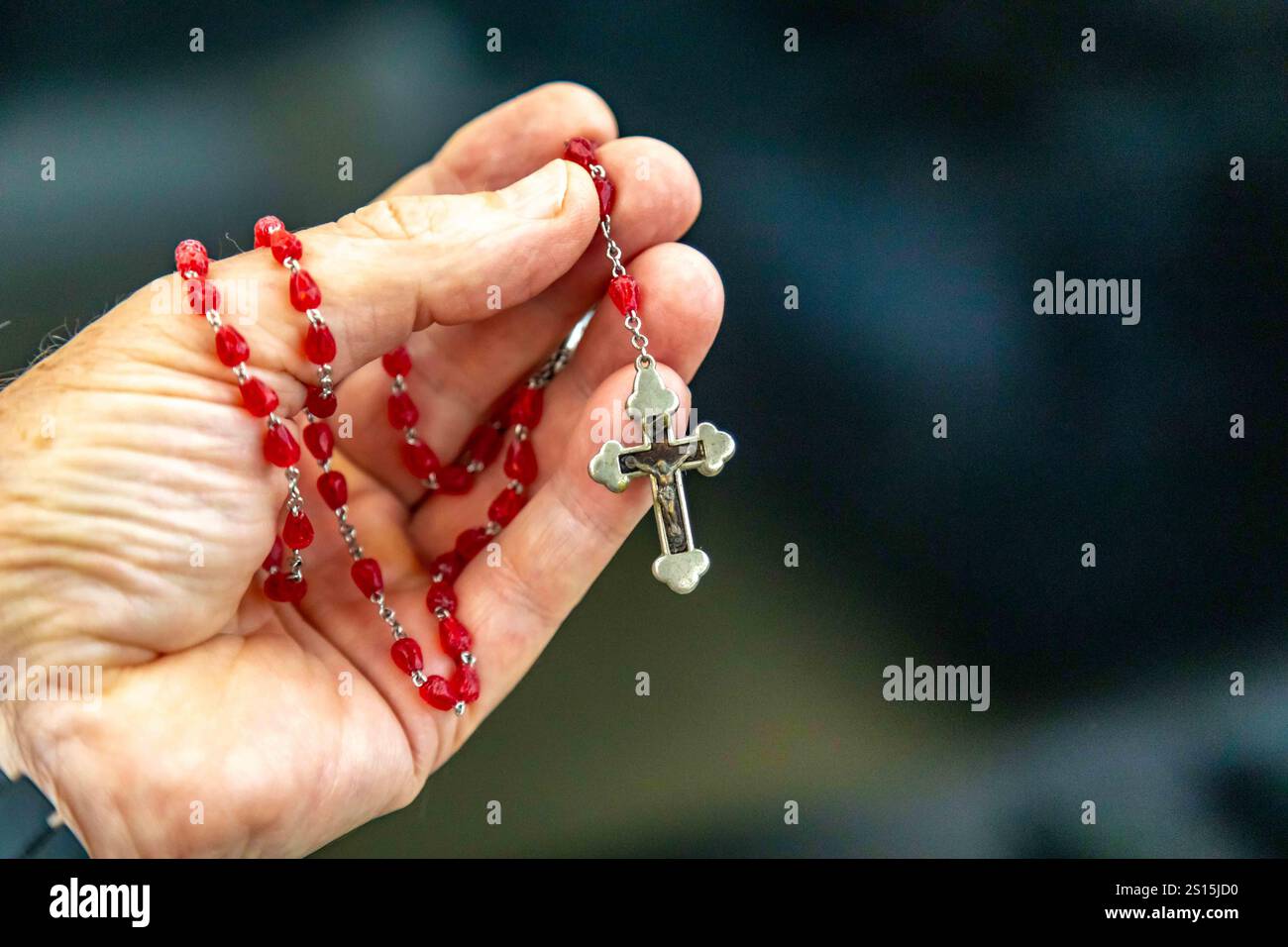 Kreatives Foto eines katholischen Rosenkranzes mit rotem Rubin ​​beads Stockfoto