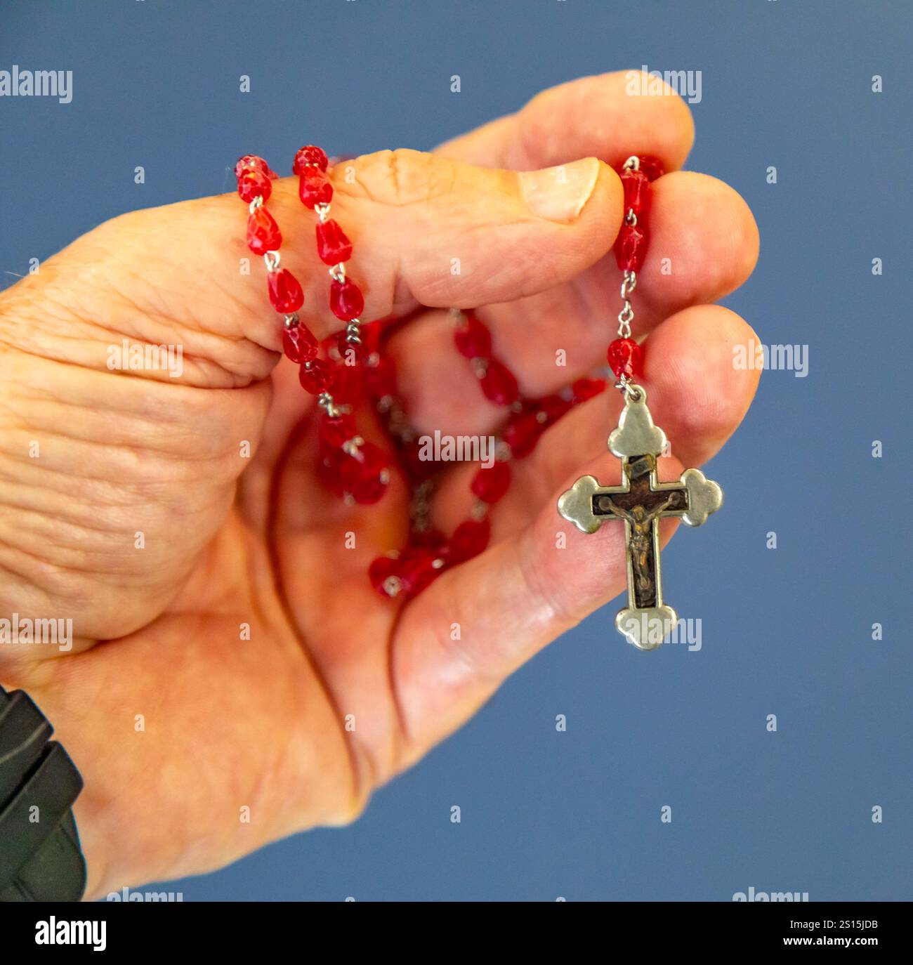 Kreatives Foto eines katholischen Rosenkranzes mit rotem Rubin ​​beads Stockfoto