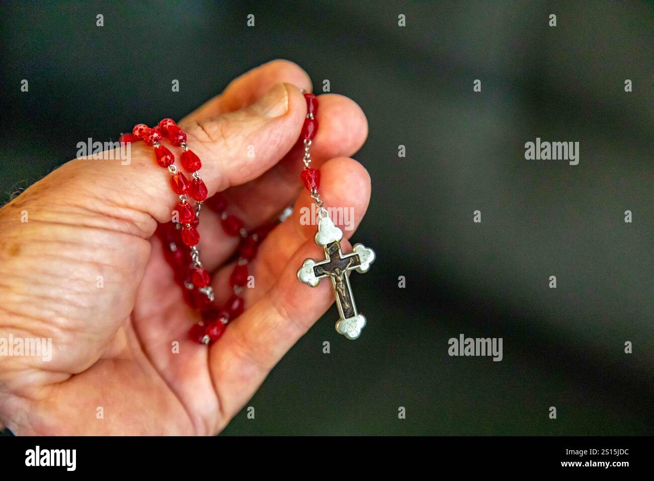 Kreatives Foto eines katholischen Rosenkranzes mit rotem Rubin ​​beads Stockfoto