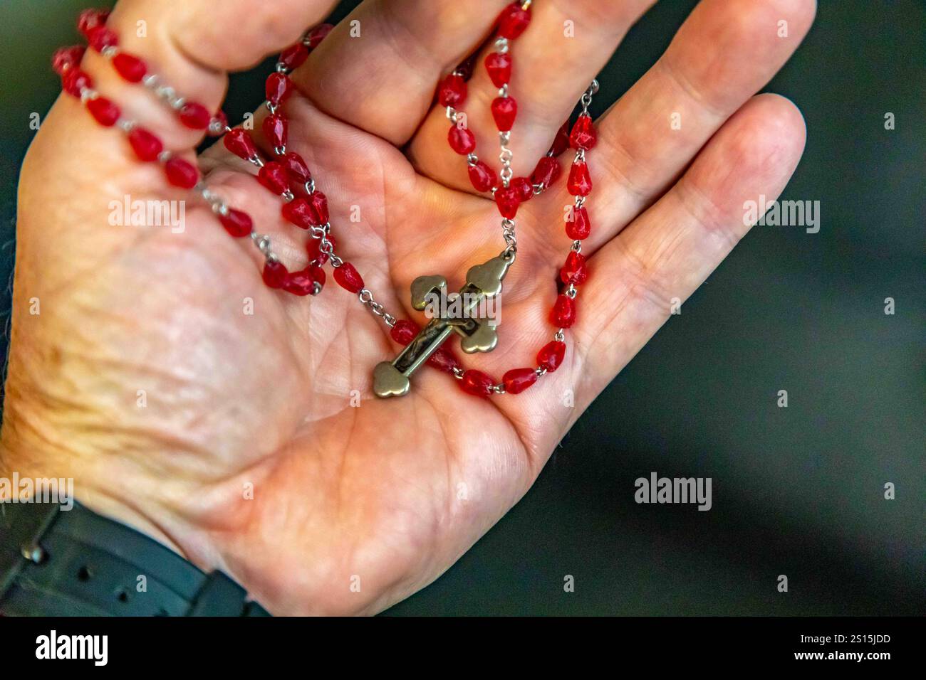 Kreatives Foto eines katholischen Rosenkranzes mit rotem Rubin ​​beads Stockfoto