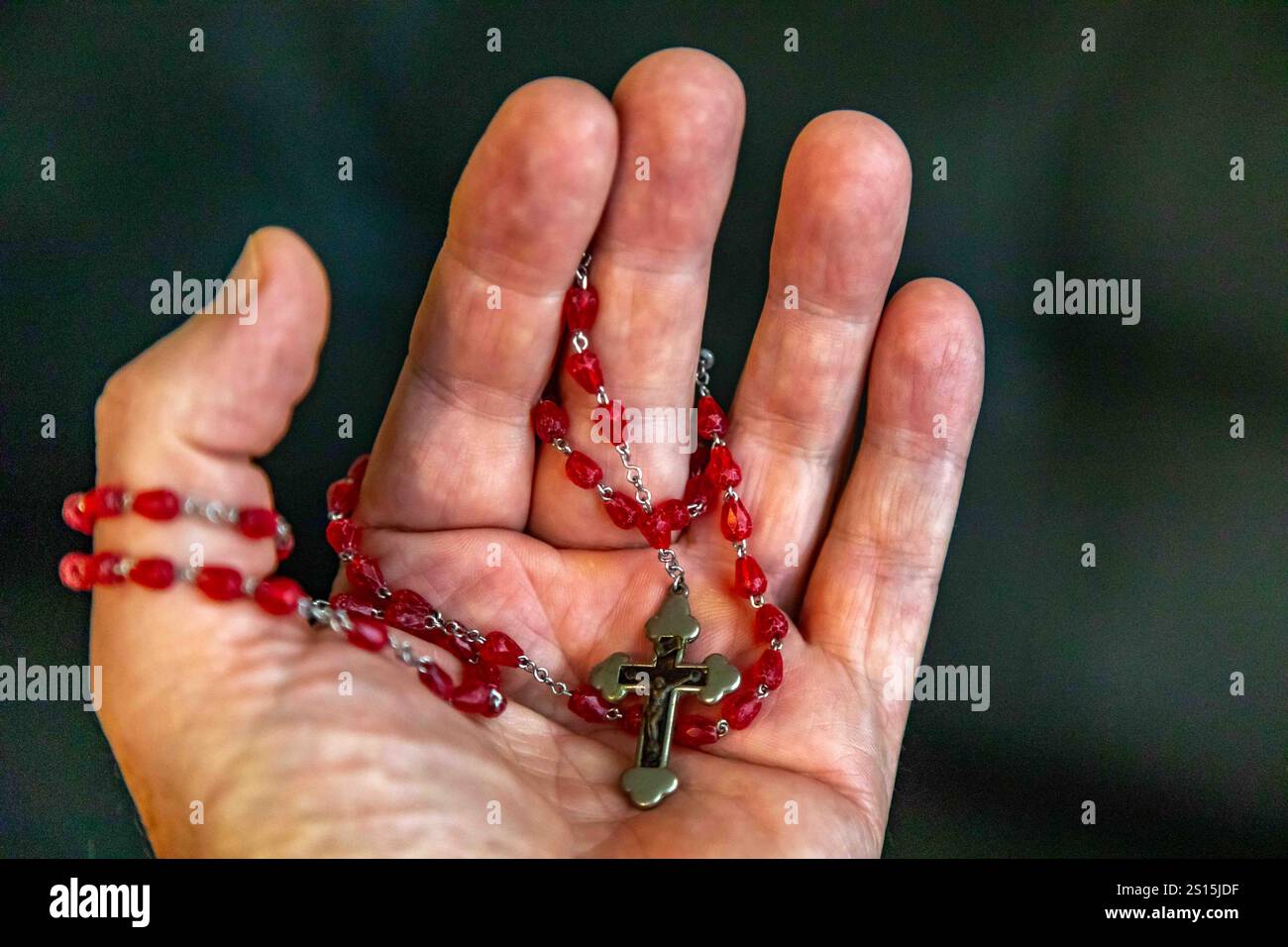 Kreatives Foto eines katholischen Rosenkranzes mit rotem Rubin ​​beads Stockfoto