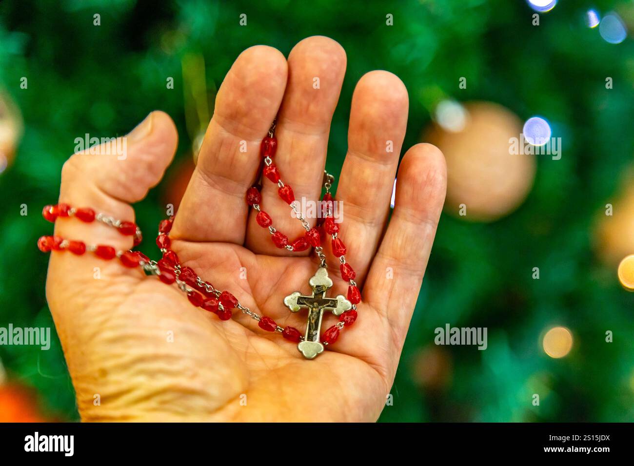 Kreatives Foto eines katholischen Rosenkranzes mit rotem Rubin ​​beads Stockfoto