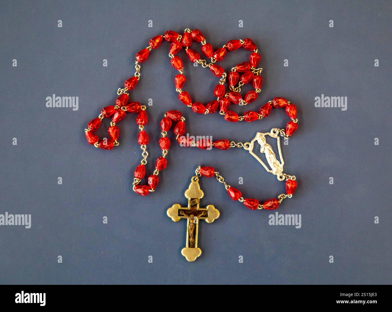 Kreatives Foto eines katholischen Rosenkranzes mit rotem Rubin ​​beads Stockfoto