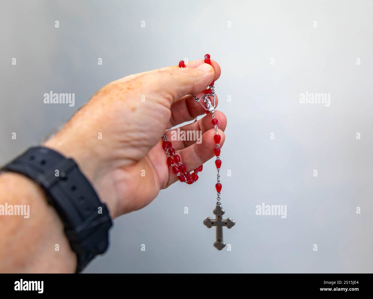 Kreatives Foto eines katholischen Rosenkranzes mit rotem Rubin ​​beads Stockfoto