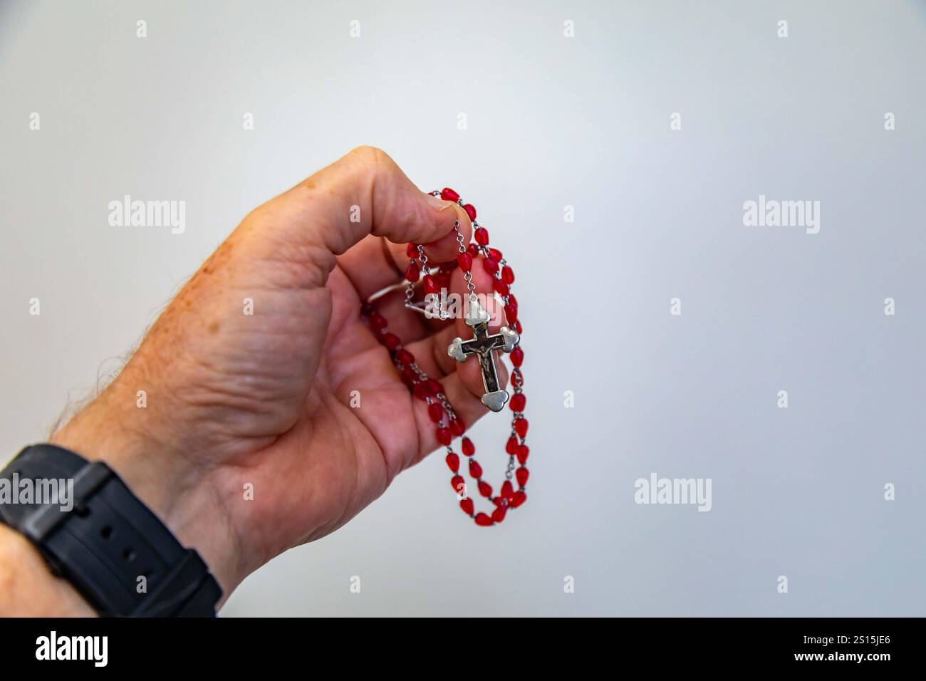Kreatives Foto eines katholischen Rosenkranzes mit rotem Rubin ​​beads Stockfoto