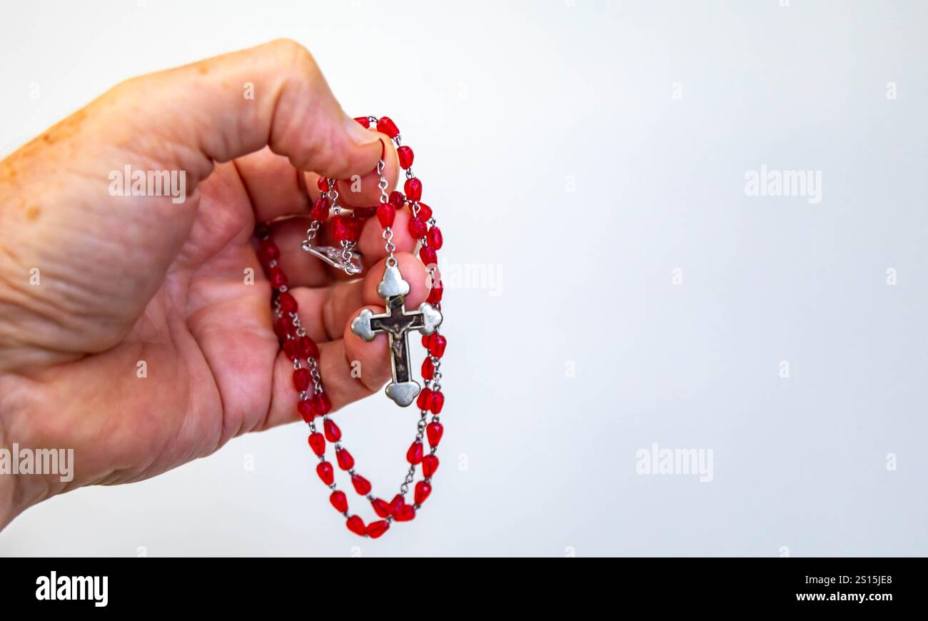 Kreatives Foto eines katholischen Rosenkranzes mit rotem Rubin ​​beads Stockfoto