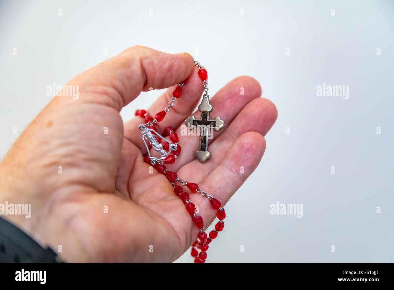 Kreatives Foto eines katholischen Rosenkranzes mit rotem Rubin ​​beads Stockfoto