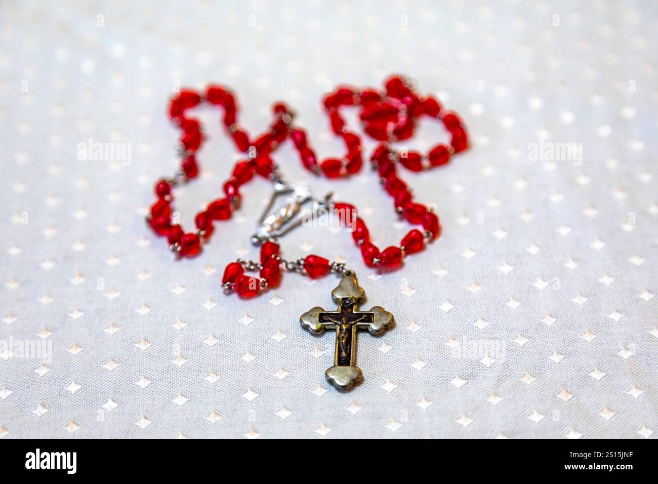 Kreatives Foto eines katholischen Rosenkranzes mit rotem Rubin ​​beads Stockfoto