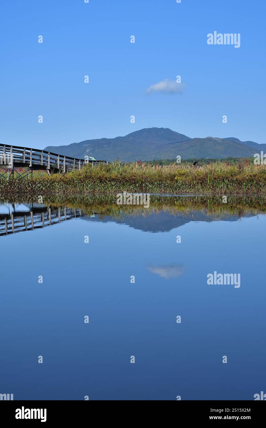 Orford Mount vom Cherry River aus gesehen. Bergreflexion auf Wasser. Fußgängerbrücke aus Holz Stockfoto