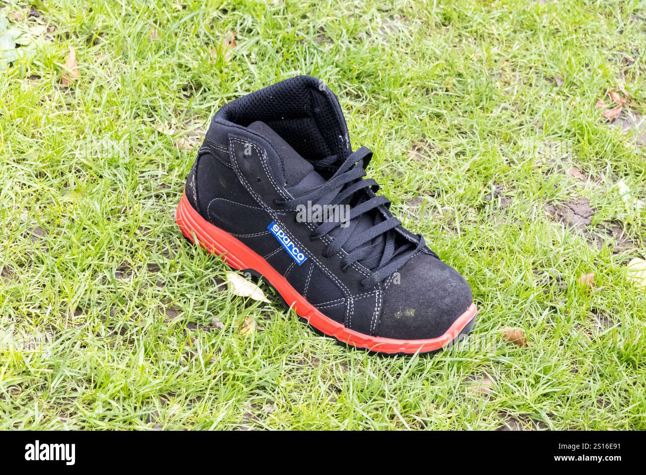 Verlorener Laufschuh am Grasrand Stockfoto Verlorener Laufschuh am Grasrand Stockfoto