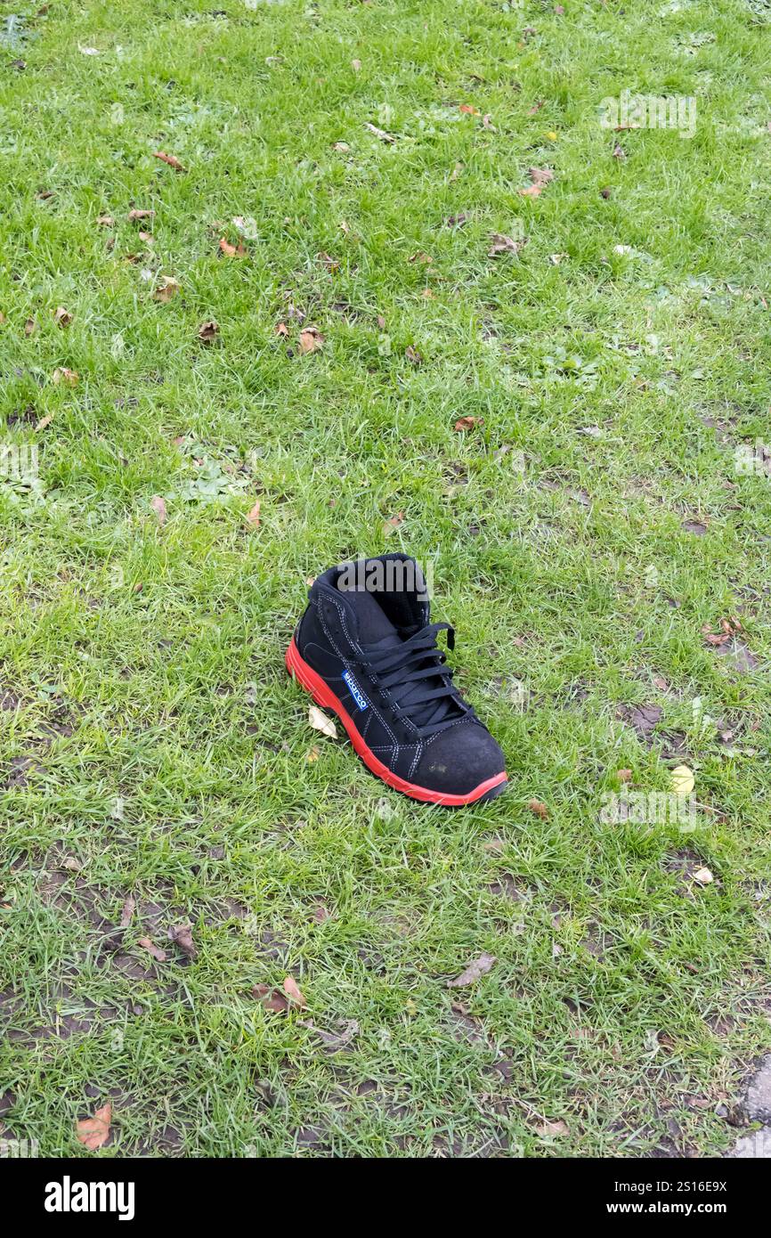 Verlorener Laufschuh am Grasrand Stockfoto Verlorener Laufschuh am Grasrand Stockfoto