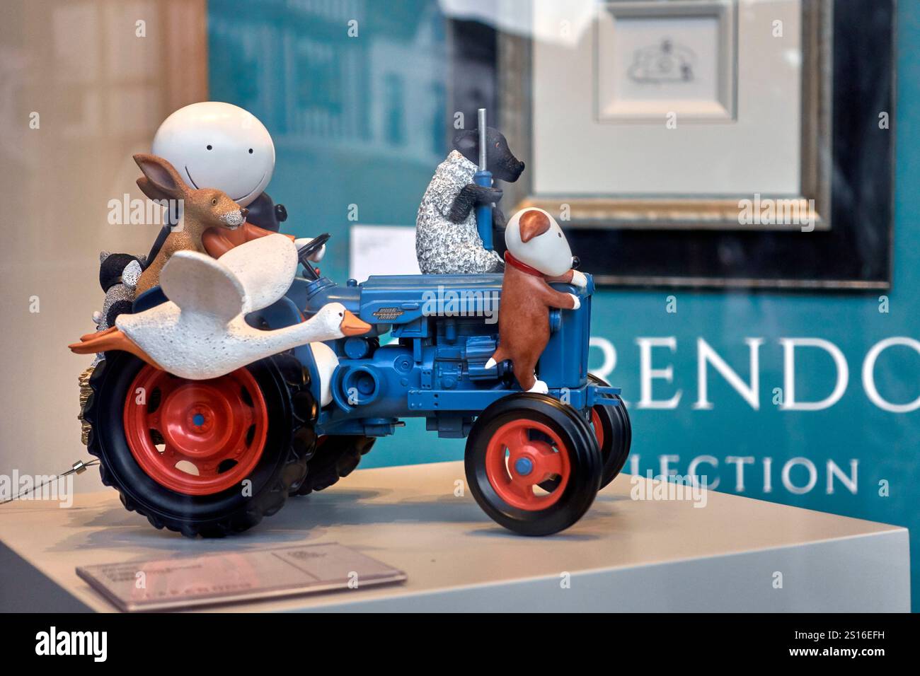 Traktorschmuck mit Fahrer umgeben von Tieren. Spielzeugkunst Stockfoto