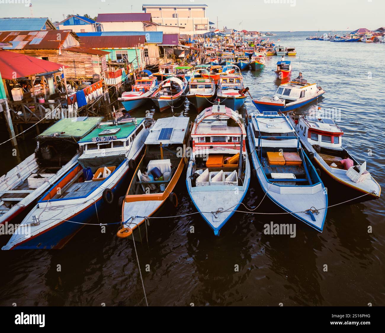 Balikpapan, Ost-Borneo, Indonesien. Eine Reihe von Booten ist in einem Hafen angedockt, mit einer roten und weißen Flagge auf einem davon Stockfoto