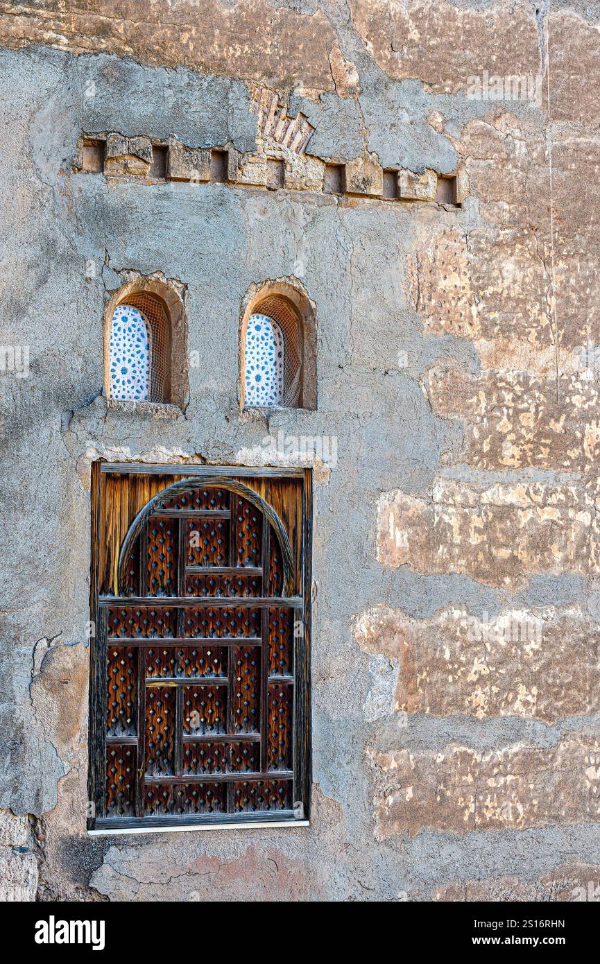 Altes Holzfenster in einer mittelalterlichen architektonischen Mauer. Stockfoto