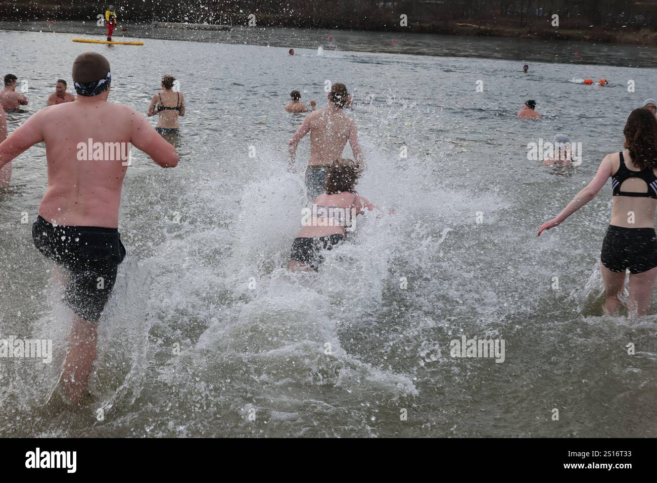 Jena, Deutschland. Januar 2025. Mehrere hundert Badefreunde schwimmen am Neujahrstag im Schleichersee bei einer Lufttemperatur von 6 Grad und einer Wassertemperatur von rund 4 Grad. Zum fünften Mal lud die Jenaer Bäder- und Freizeitgesellschaft 2025 zum gemeinsamen Schwimmen im Südbad ein. Quelle: Bodo Schackow/dpa/Alamy Live News Stockfoto