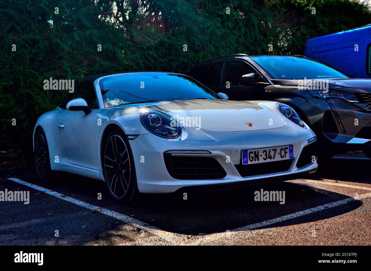 Saint-Victor-sur-Loire, Frankreich - 6. Oktober 2024 : der Blick auf einen schönen weißen porsche carrera, der in der Nähe einer Reihe von Bäumen parkt. Stockfoto