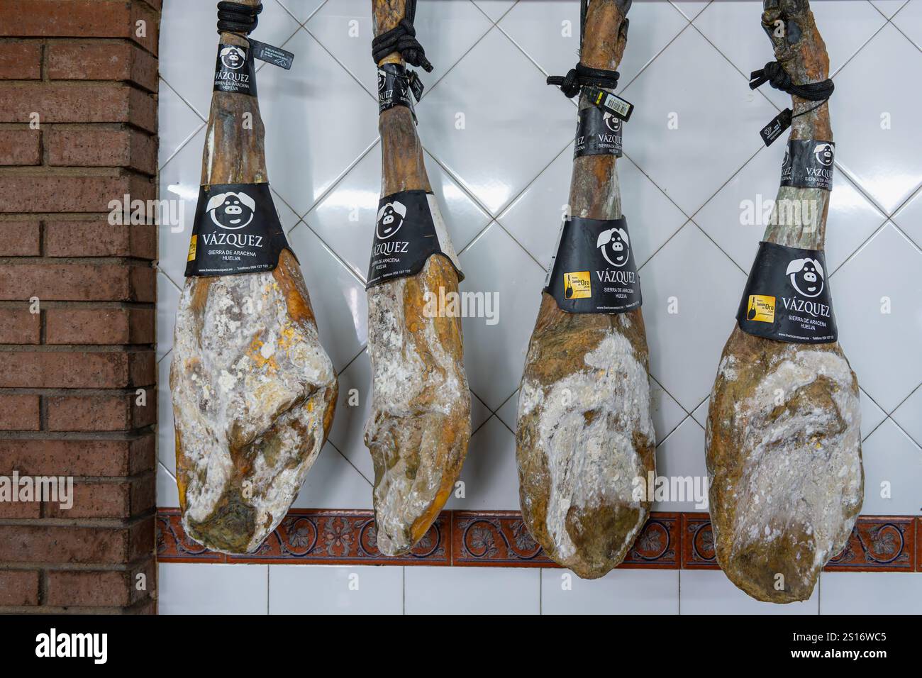 Sierra de Aracena, Spanien - 6. November 2024: Vier iberische Schinkenschenkel mit schwarzen Etiketten für höchste Qualität. Die Schinken sind klassifiziert b Stockfoto