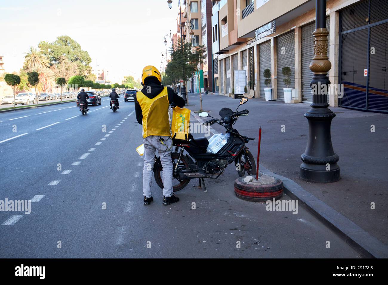 glovo-Moped-Fahrer, der Moto in gueliz marrakesch, marokko verpackt Stockfoto