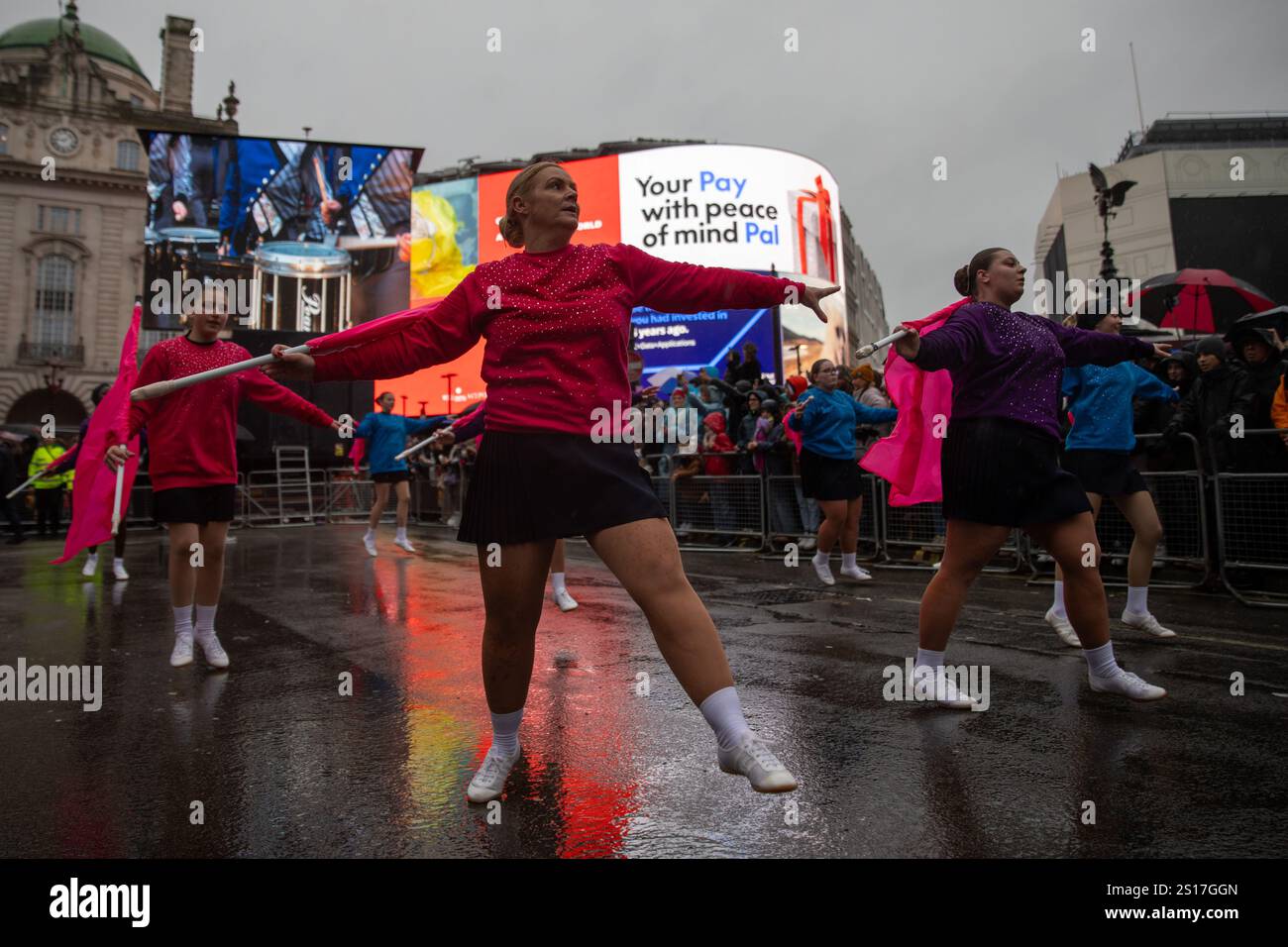London, UK, 1. Januar 2025. Tänzer winken während einer Parade mit Schlagstöcken. Tausende von Zuschauern trotzen starkem Wind und starkem Wind, um an der jährlichen London New Year Day Parade 2025 teilzunehmen. Quelle: James Willoughby/ALAMY Live News Stockfoto