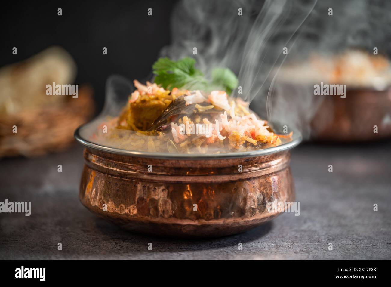 Rauchig scharfer indischer Biryani-Pulao in goldener Schüssel mit indischem Basmati-Reisgericht mit Hühnerfleisch-Curry Ramadan Kareem, Eid. Servierschüssel aus Messing mit Weißwein Stockfoto