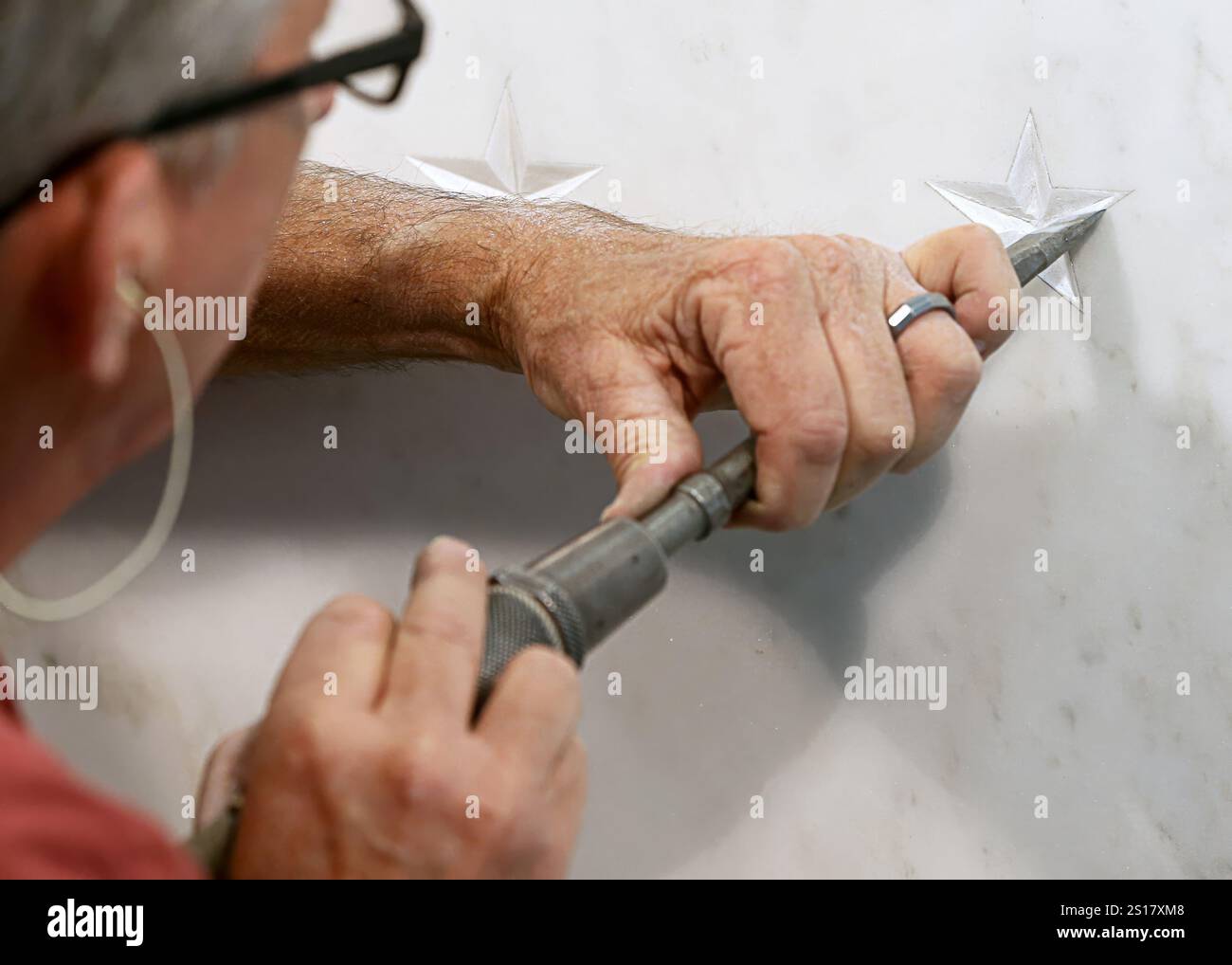 Langley, Vereinigte Staaten von Amerika. 23. Mai 2017. Der Steinschnitzer Tim Johnston schnitzt einen neuen Stern, der einen CIA-Offizier repräsentiert, der im Dienst an der Central Intelligence Agency Memorial Wall an der Nordwand der ursprünglichen Hauptquartierslobby am 23. Mai 2017 in Langley, Virginia, getötet wurde. Quelle: CIA/Central Intelligence Agency/Alamy Live News Stockfoto