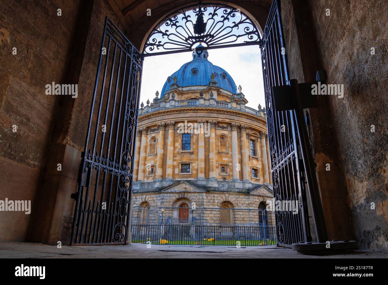 Oxford, England – gerahmter Blick auf die Radcliffe-Kamera durch kunstvolle Eisenrasten, die historische neoklassizistische Architektur und eine einzigartige Perspektive zeigt Stockfoto