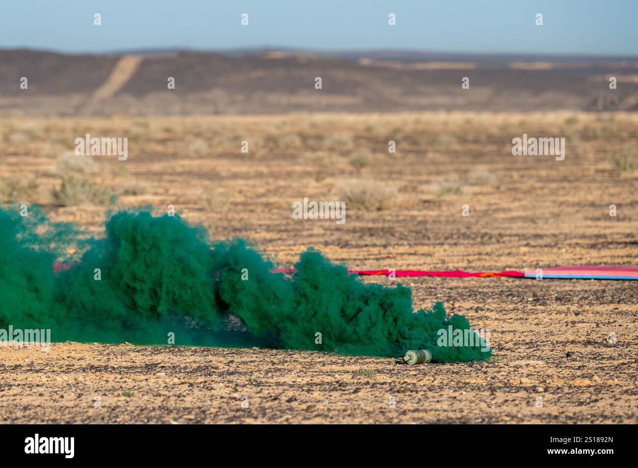 Eine Rauchgranate markiert die Fallzone und zeigt die Windgeschwindigkeit und -Richtung für pararescuemen an, die der 52nd Expeditionary Rescue Squadron während einer isolierten Personalbergungsübung an einem nicht offengelegten Ort im US-Zentralkommando am 2. März 2024 zugeteilt wurden. Isolierte Bergungsübungen ermöglichen es den USA und ihren Alien, ein hohes Maß an Bereitschaft und Fachkompetenz bei Bergungsoperationen aufrechtzuerhalten. (Foto der U.S. Air Force von Staff Sgt. Caleb Roland) Stockfoto