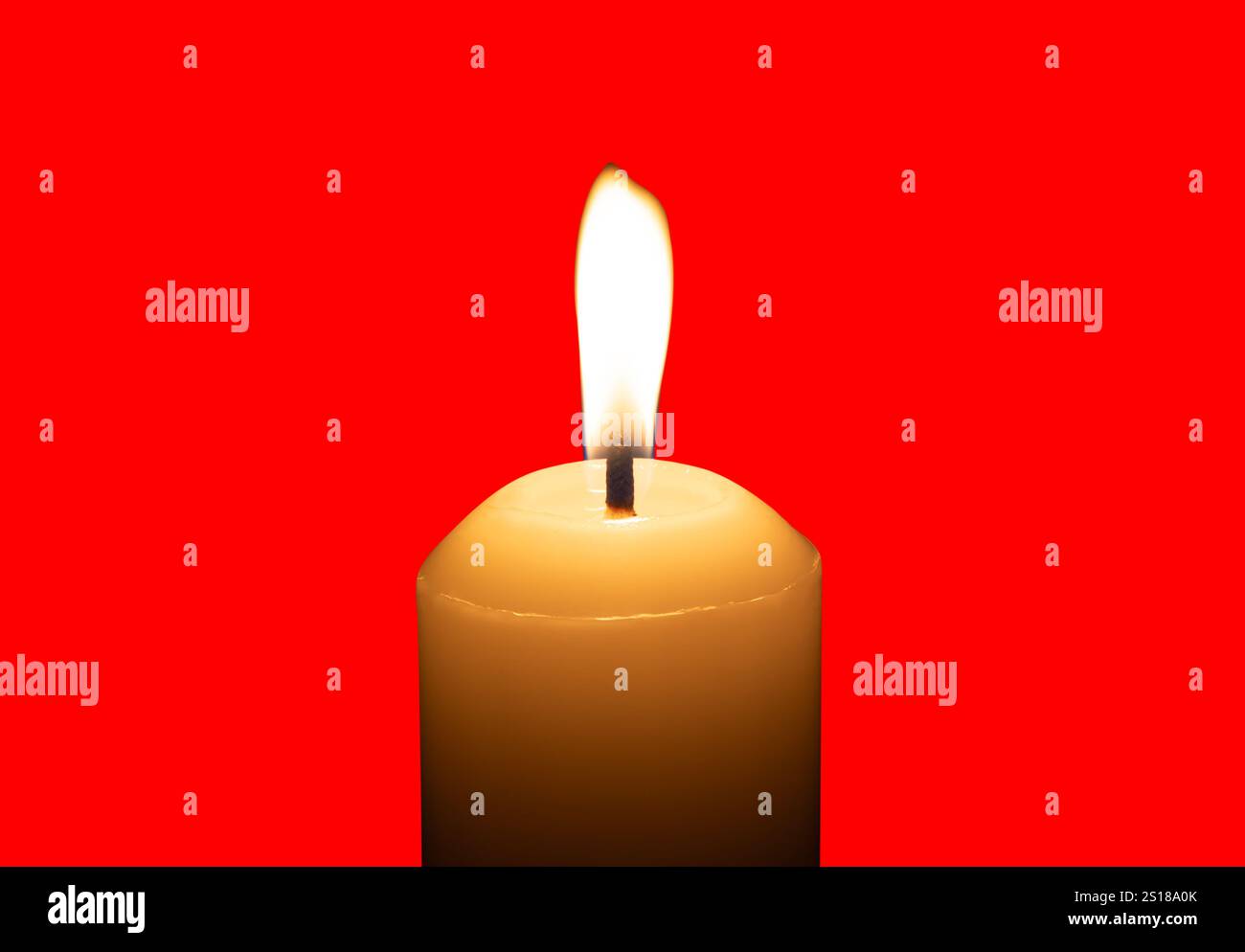 Eine einzelne brennende Kerzenflamme oder ein Licht, das auf einer großen weißen Kerze leuchtet, ist auf rotem Hintergrund mit Beschneidungspfad isoliert. Stockfoto