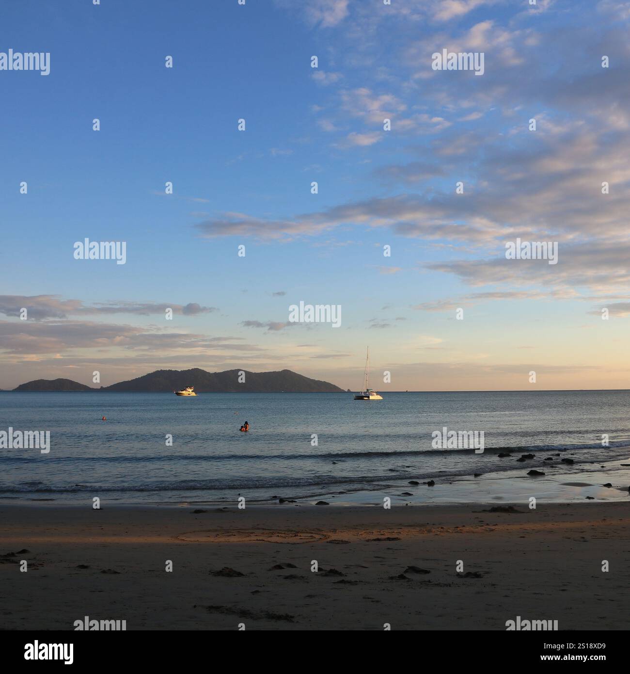 Katamaran und Ko Khlum, kleine Insel mit Blick auf den Sonnenuntergang vom Strand Klong Kloi, Koh Chang, Thailand. Stockfoto