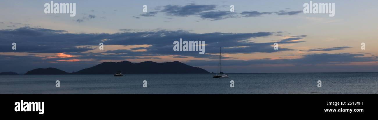 Katamaran und Ko Khlum, kleine Insel mit Blick auf den Sonnenuntergang vom Strand Klong Kloi, Koh Chang, Thailand. Stockfoto