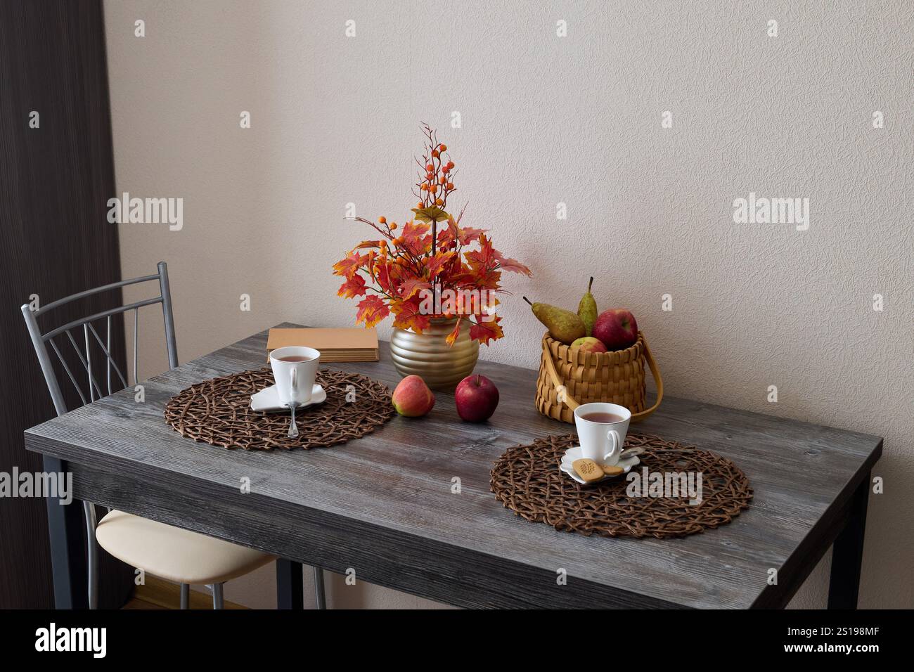 Erleben Sie einen gemütlichen Herbsttisch mit Blumen und Früchten Stockfoto