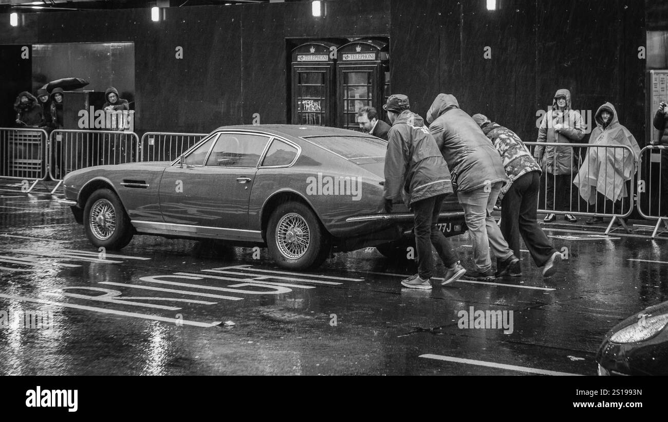 Zuschauer helfen bei der Neujahrsparade 2025 in London mit einem gefallenen Auto. Stockfoto