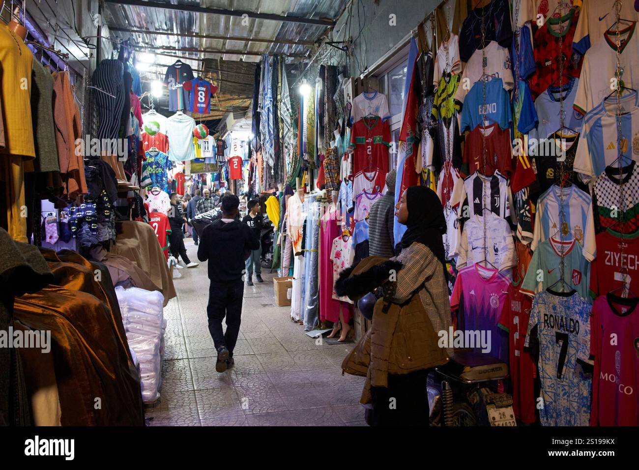 Kleidung und Fußballtrikot zum Verkauf bei Nacht im Souk el bahja vor dem jemaa el-fna Platz marrakesch, marokko Stockfoto