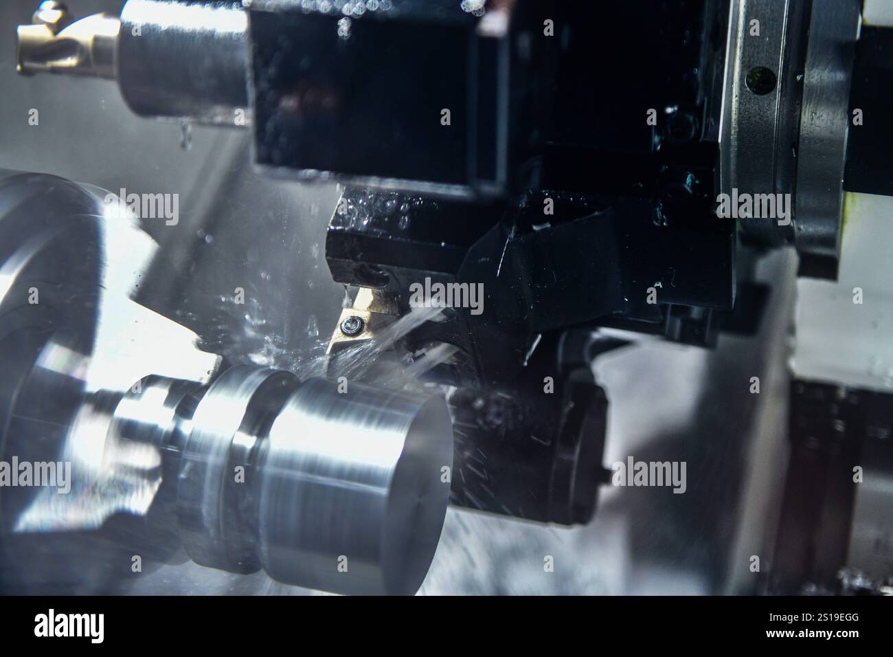 Schneiden von Stahlmetallwellen auf Drehmaschinen in der Werkstatt, in der metallverarbeitenden Industrie Stockfoto