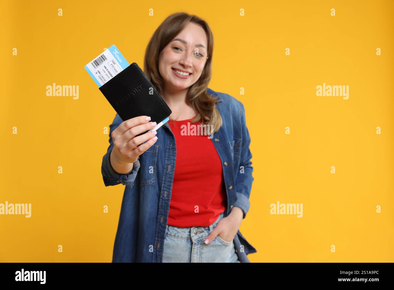 Glücklicher Reisender mit Pass und Ticket auf gelbem Hintergrund, selektiver Fokus Stockfoto