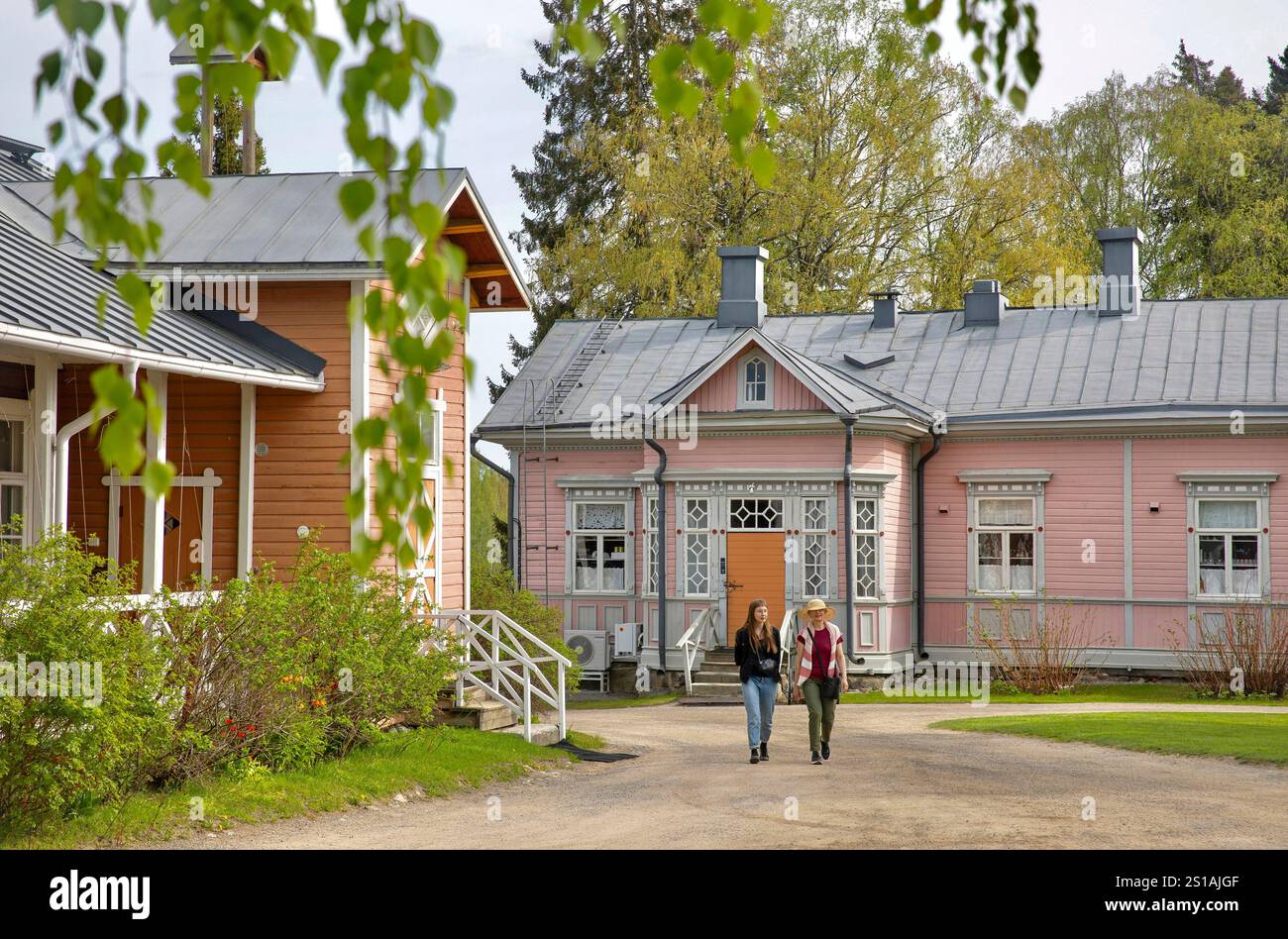 Finlande, Région des lacs, Mikkeli, manoir de Tertti, femmes finlandaises marchant entre de vieux bâtiments en bois coloré/Finnland, Seengebiet, Mikkeli, Herrenhaus Tertlli, finnische Frauen, die zwischen alten hölzernen Farbenhäusern spazieren gehen Stockfoto