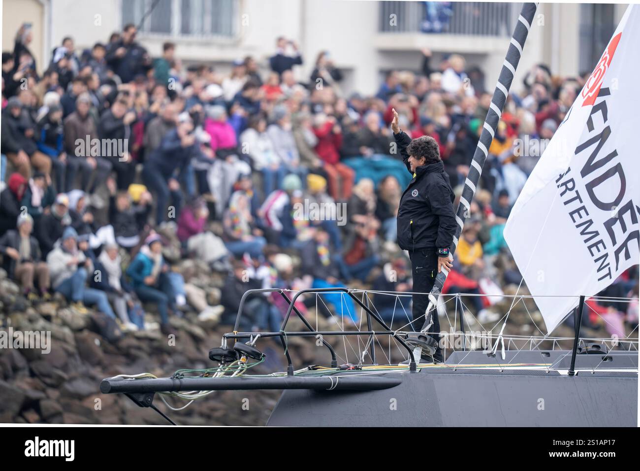 Frankreich, Vendée, Les Sables d'Olonne, Abflugtag Vendée Globe, Skipper Jean Le Cam verlässt den Kanal und winkt der Menge von seinem IMOCA zu *Tout begin en Finistère* Stockfoto